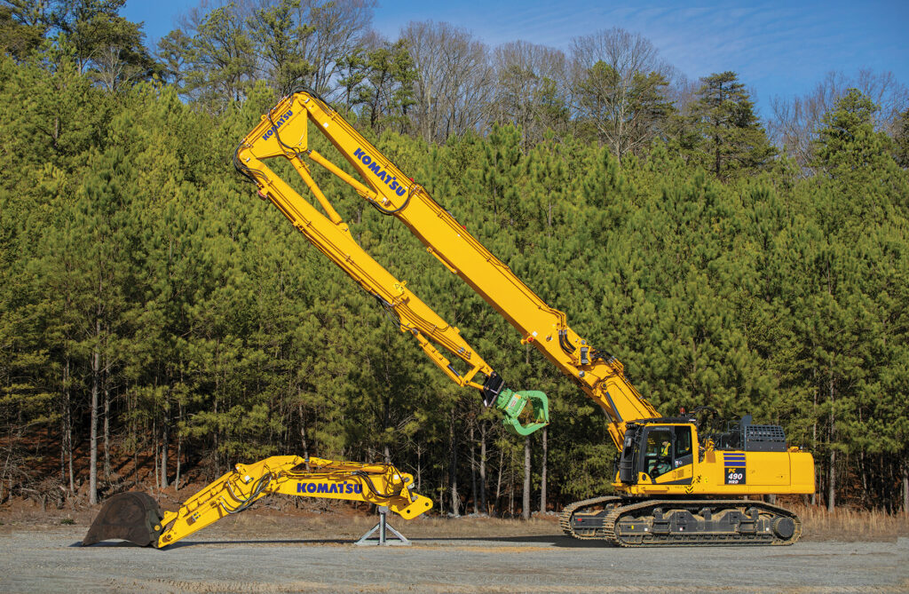 An image of a Komatsu PC490HRD-11 excavator with an optional reconfiguration shown in front of it.