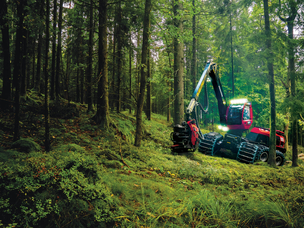 A front-facing image of a Komatsu 951XC wheeled harvester moving through the forest.