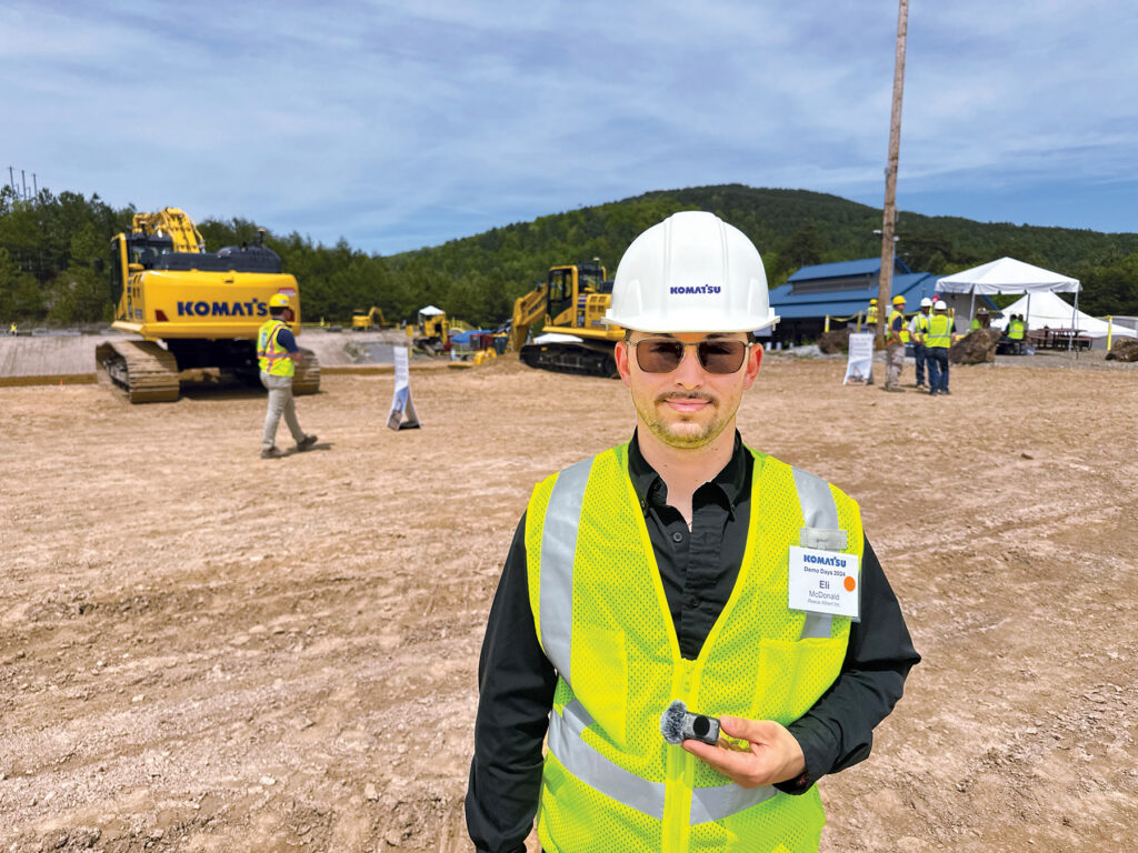 An image of Eli McDonald, Equipment Coordinator at Reece Albert Inc. and CSA Materials Inc., wearing a white hard hat and a reflective vest at Demo Days.