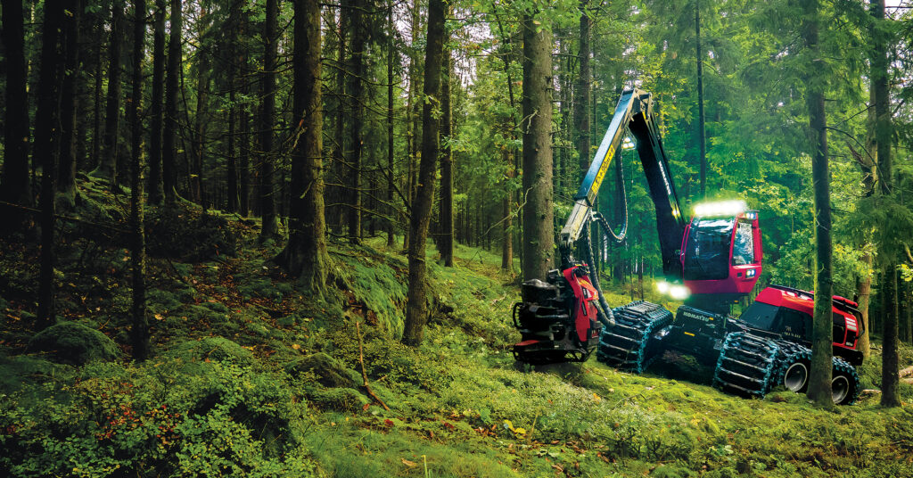 A front-facing image of a Komatsu 951XC wheeled harvester moving through the forest.